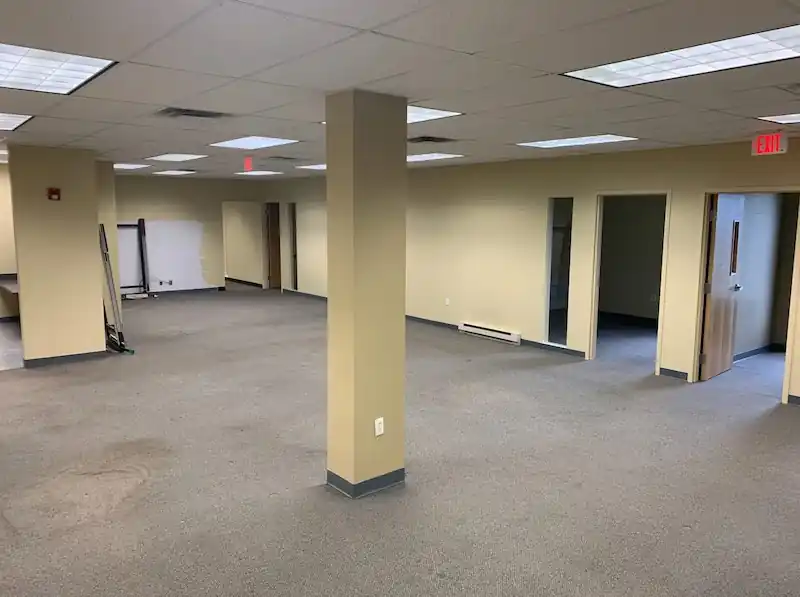 Open Jersey City office floor with carpet, support columns and no cubicles