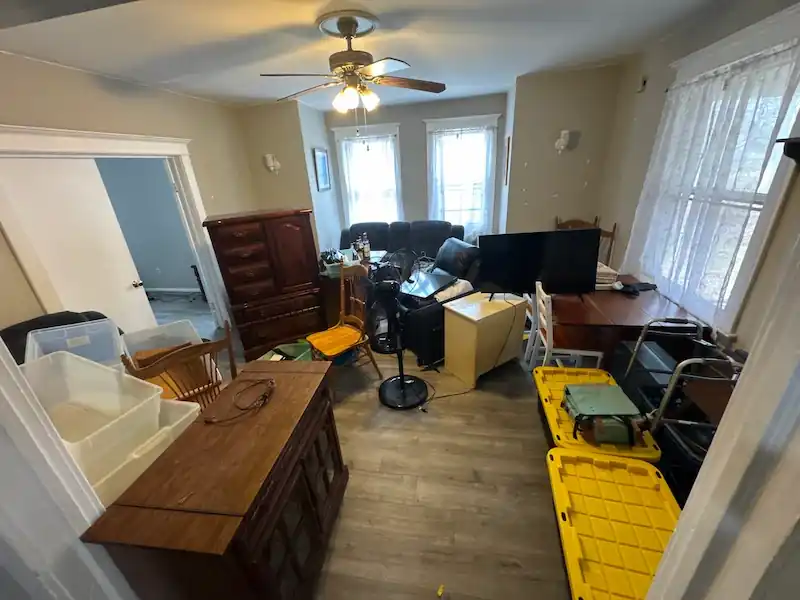 Jersey City apartment living room crowded with a dresser, bins and furniture