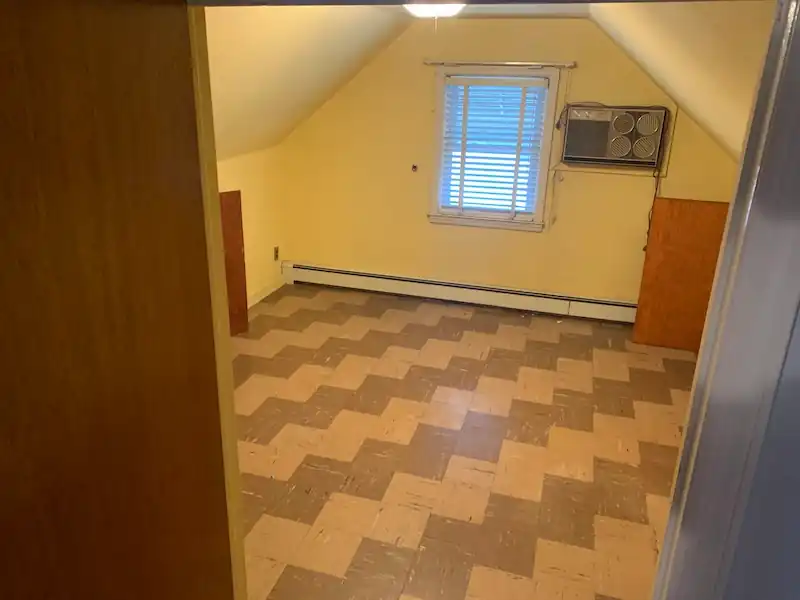 Glen Ridge attic room empty, showing the checkerboard floor and the window