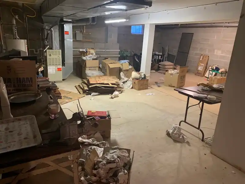 Cranford basement with boxes, tables and loose debris across the floor