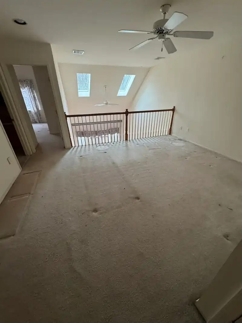 Upstairs room with skylights and a ceiling fan after the furniture went out