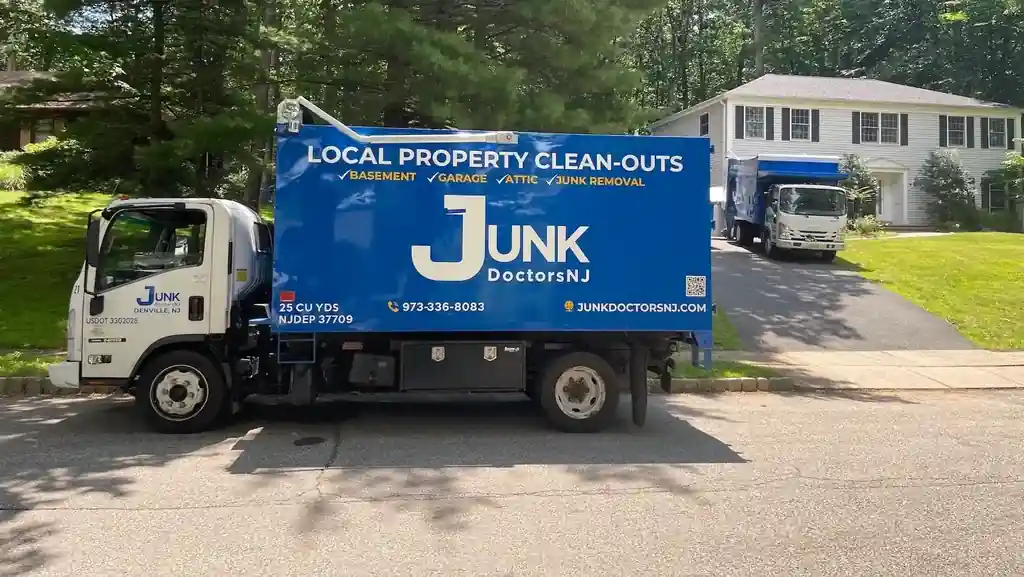 Two JunkDoctors box trucks parked on a suburban New Jersey street