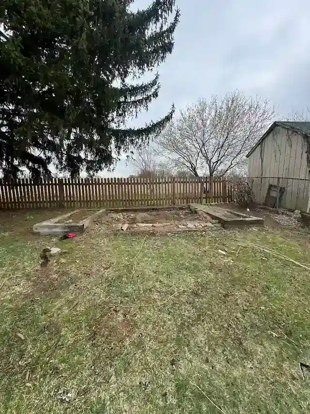 The same backyard with the shed removed and open lawn where it stood