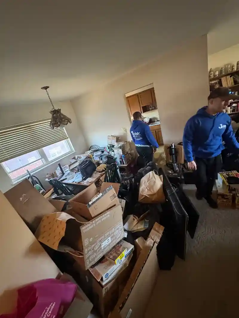 JunkDoctors crew working through a crowded room full of boxes and furniture
