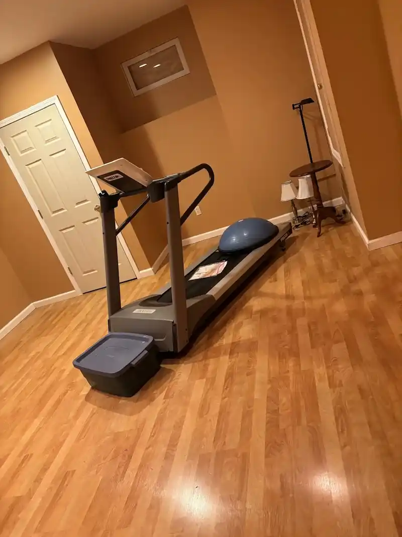 Treadmill standing on a wood floor in a Ridgewood basement room