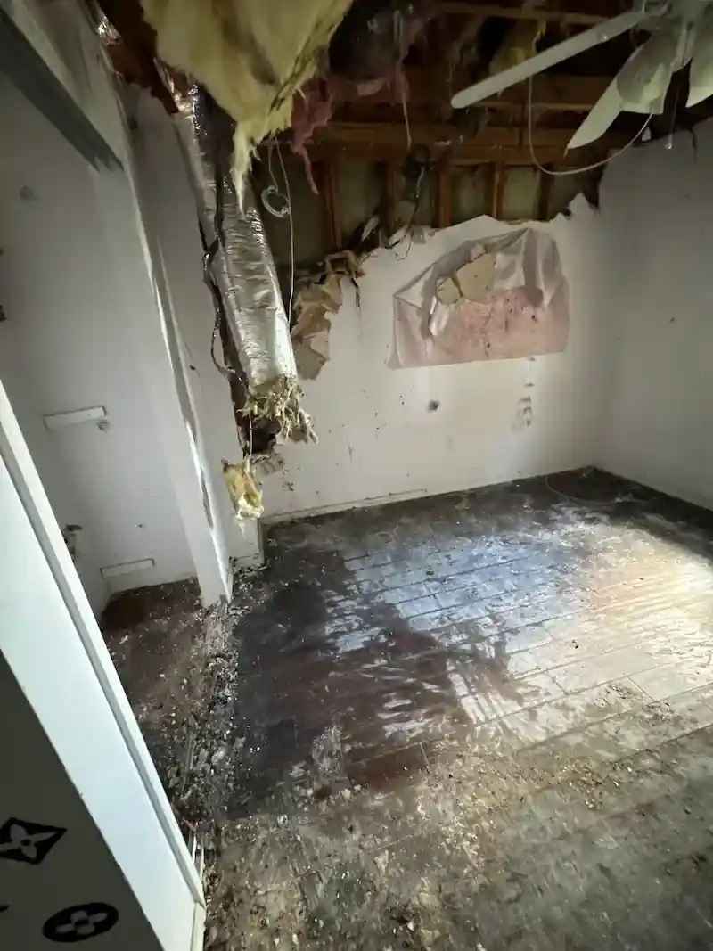 The same water-damaged room cleared of debris down to the subfloor