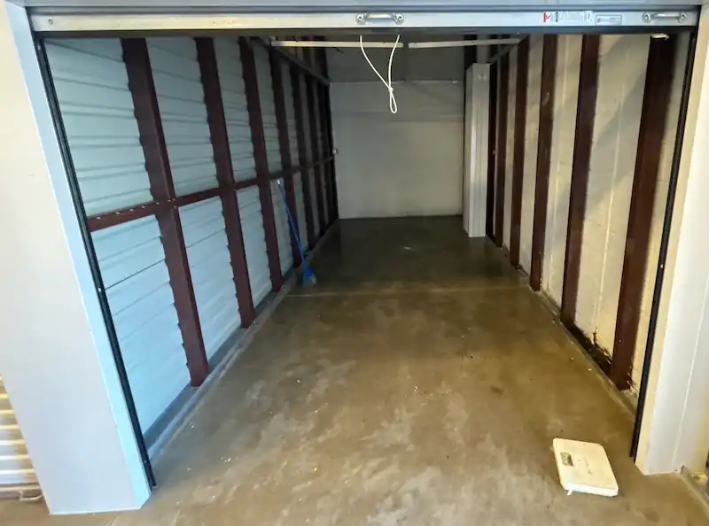 Empty Woodbridge storage unit with the roll-up door open and the floor swept